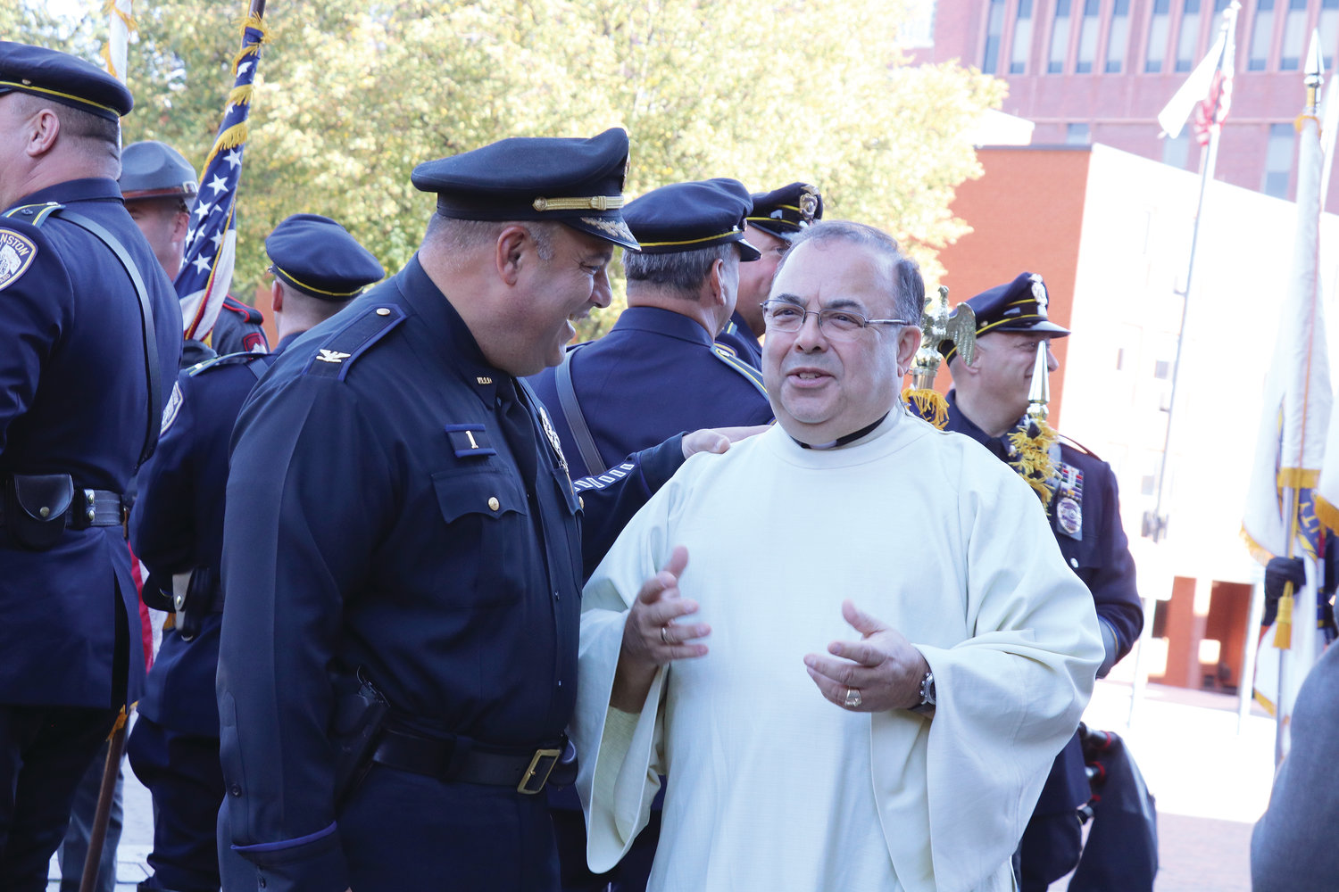 Father Joseph Escobar, pastor of Our Lady of the Rosary Parish in Providence, who has served as chaplain to the Rhode Island Police Chiefs Association since 2006, smiles with North Providence Police Chief David Tikoian.